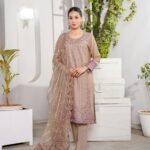 Charming woman in traditional outfit standing indoors in Lahore, Pakistan.
